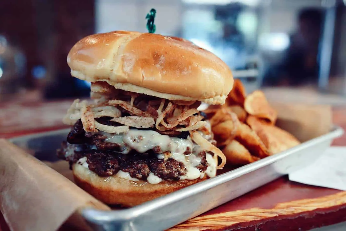 Burger with crispy fried onions and a side of chips