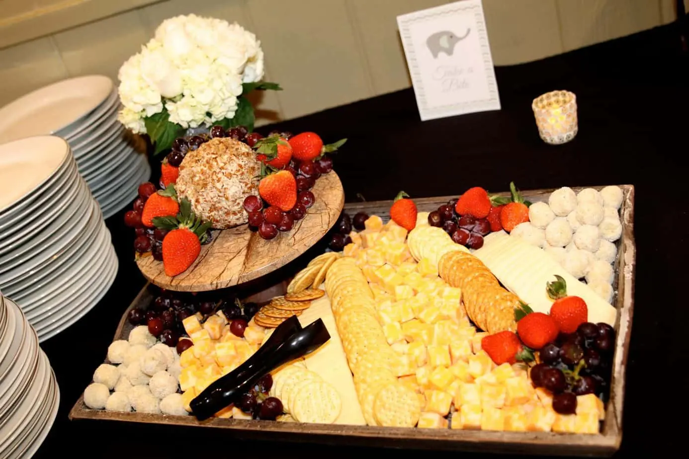 Catering table with cheeses, crackers, berries and a cheese ball