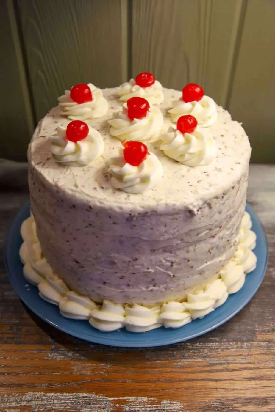 Layer cake topped with whipped cream and cherries