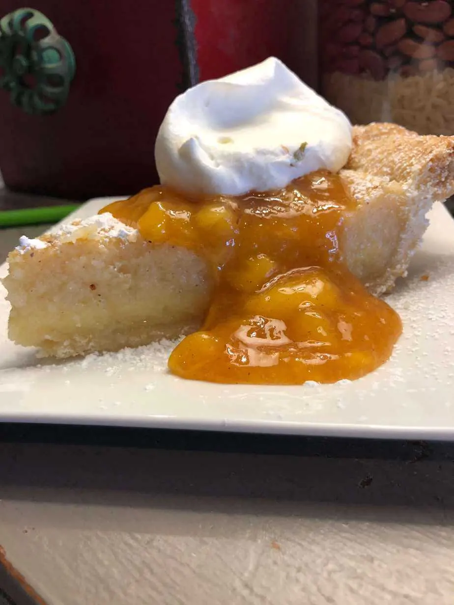 Slice of dessert with a warm fruit sauce and whipped cream