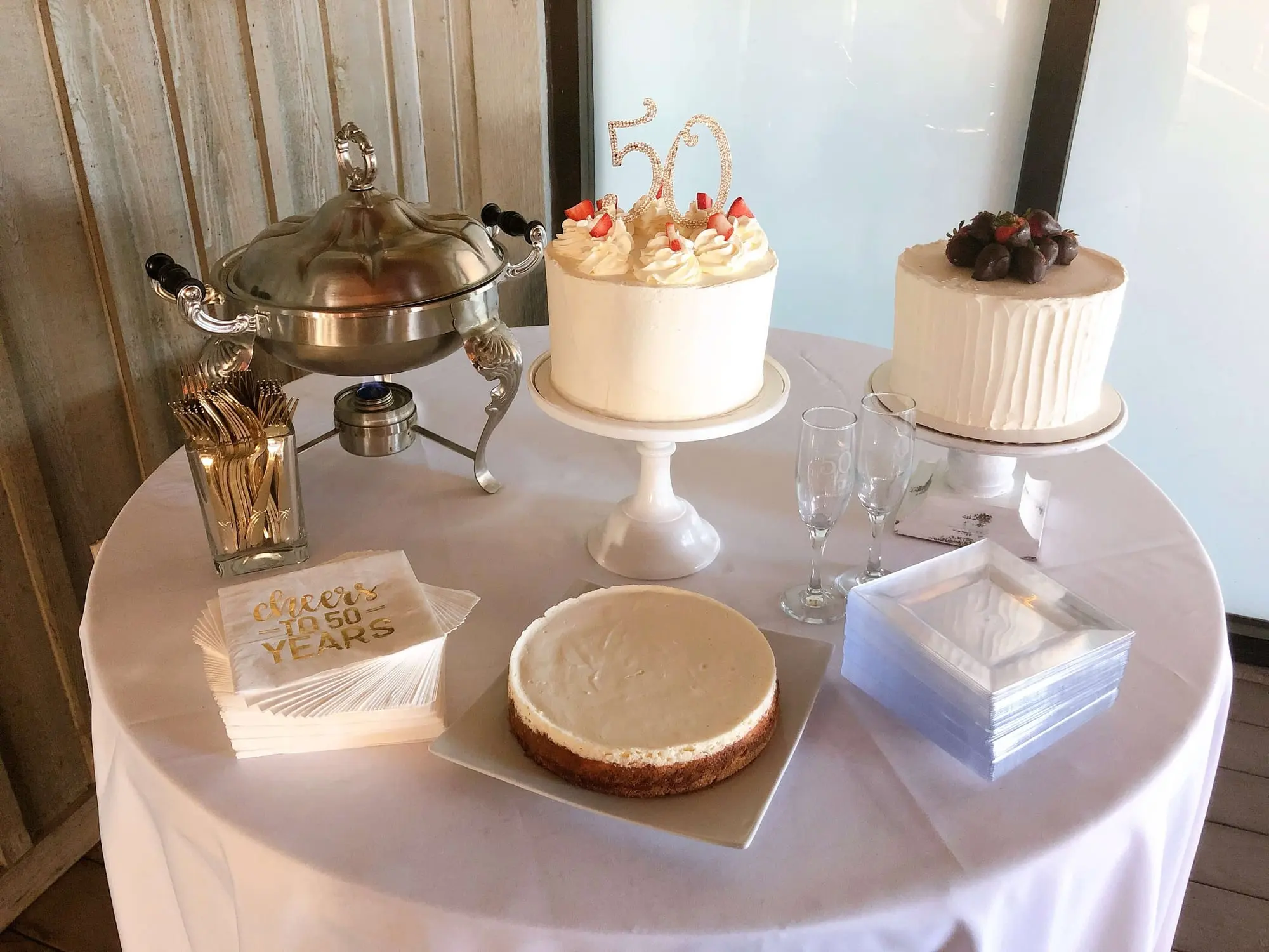 Event dessert table with cakes and a silver chafing dish