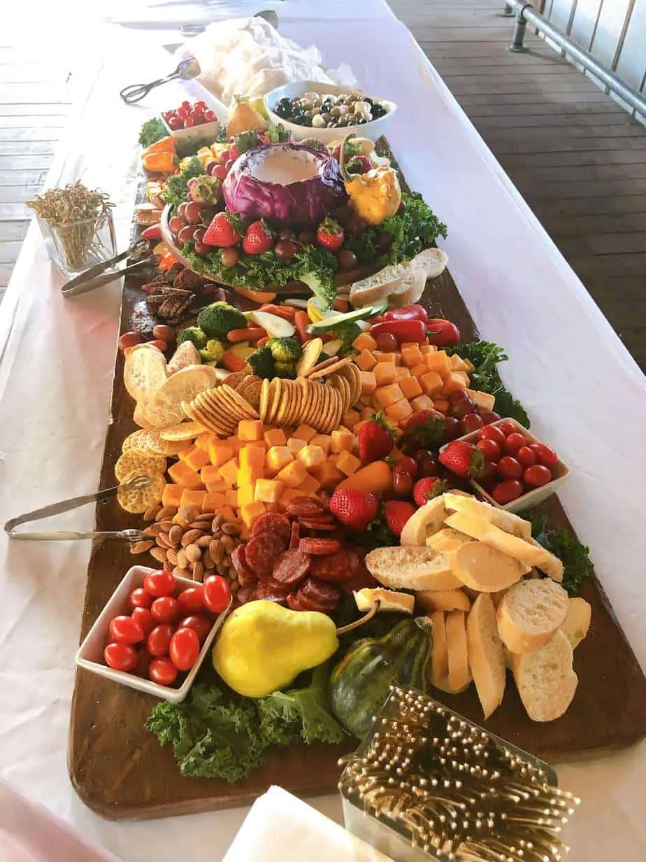 Long grazing table with fruit, vegetables, cheeses and crackers