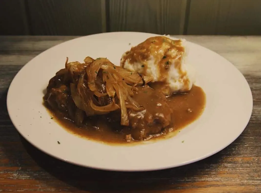 Smothered meat in onion gravy with mashed potatoes